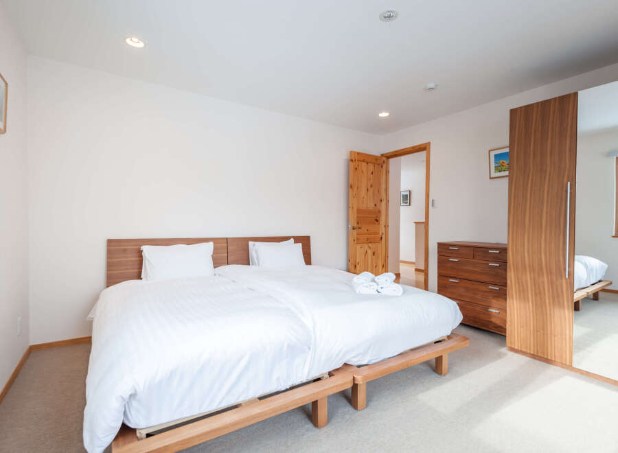 This bright and airy bedroom boasts a comfortable double bed with crisp white linens, perfect for a relaxing stay.