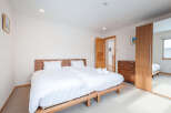 This bright and airy bedroom boasts a comfortable double bed with crisp white linens, perfect for a relaxing stay.
