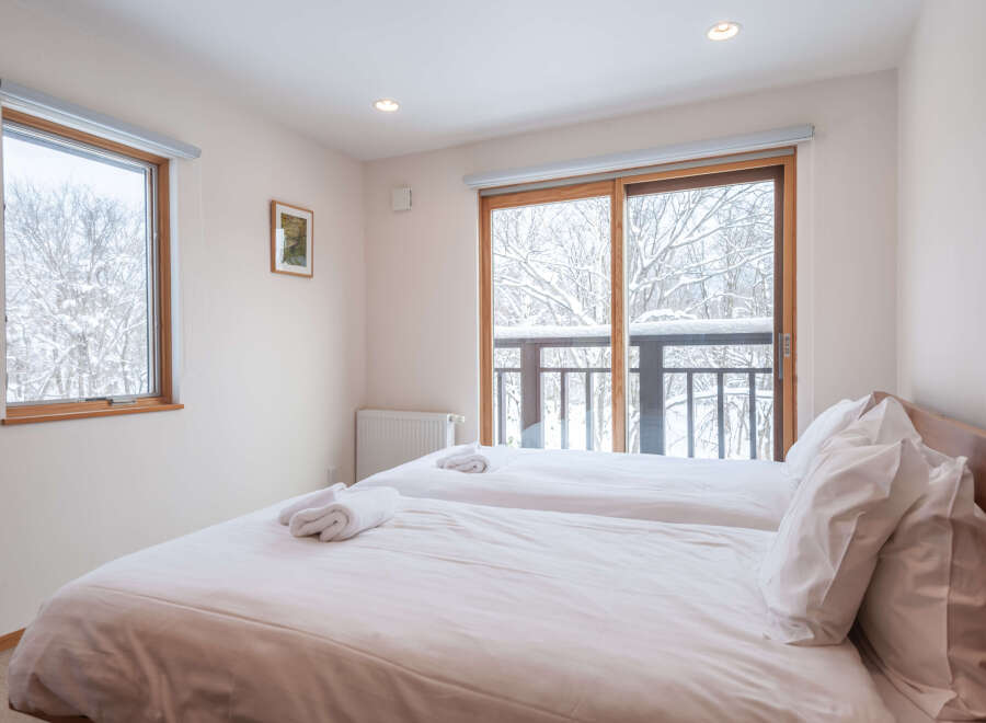 Wake up to stunning views of a snow-covered landscape from this cozy twin bedroom.