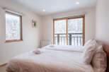 Wake up to stunning views of a snow-covered landscape from this cozy twin bedroom.