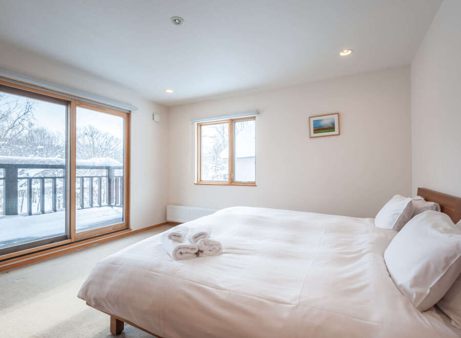 Wake up to breathtaking views of a snow-covered landscape from this cozy bedroom.