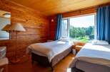 This cozy wooden room features two single beds, perfect for a relaxing getaway.