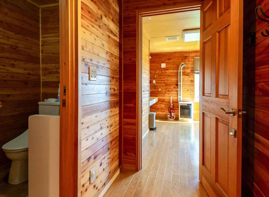This charming wooden cabin boasts a cozy interior with knotty pine walls and hardwood floors throughout.