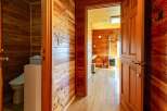 This charming wooden cabin boasts a cozy interior with knotty pine walls and hardwood floors throughout.