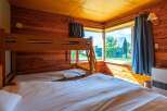 Cozy cabin room with a bunk bed and a large comfortable bed, perfect for families.