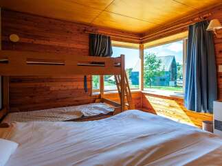 Cozy cabin room with a bunk bed and a large comfortable bed, perfect for families.
