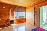 This charming wooden room features a spacious layout with a large window, providing ample natural light.