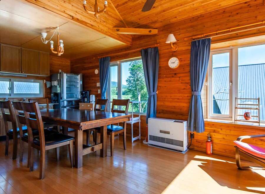 This cozy log cabin boasts a spacious dining area with a large wooden table and comfortable chairs, perfect for family meals.