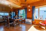 This cozy log cabin boasts a spacious dining area with a large wooden table and comfortable chairs, perfect for family meals.