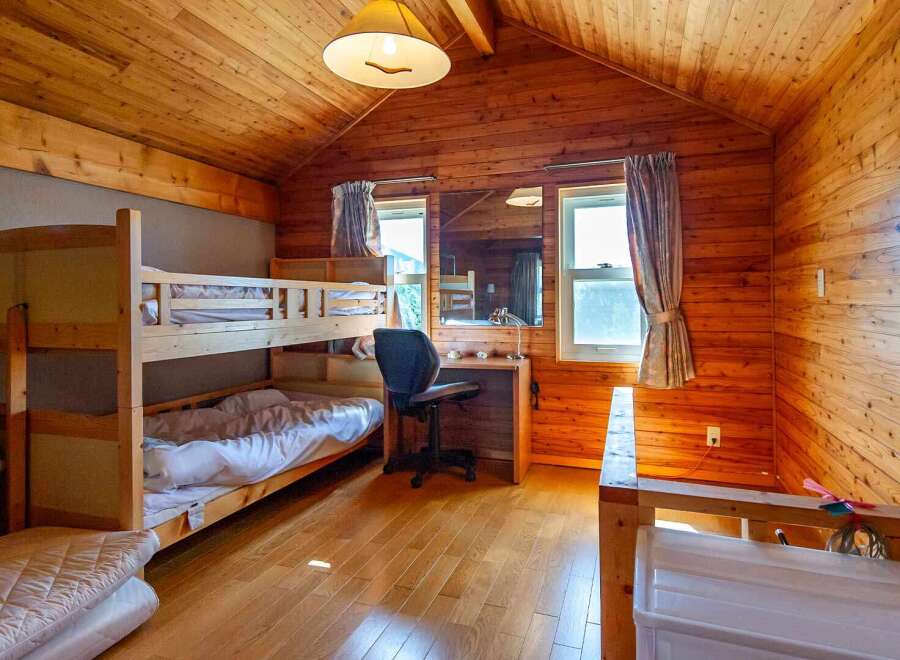 Cozy wooden cabin room with a bunk bed, perfect for a family getaway.
