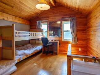 Cozy wooden cabin room with a bunk bed, perfect for a family getaway.