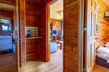 Cozy wooden cabin with a bathroom, living area, and bedroom.