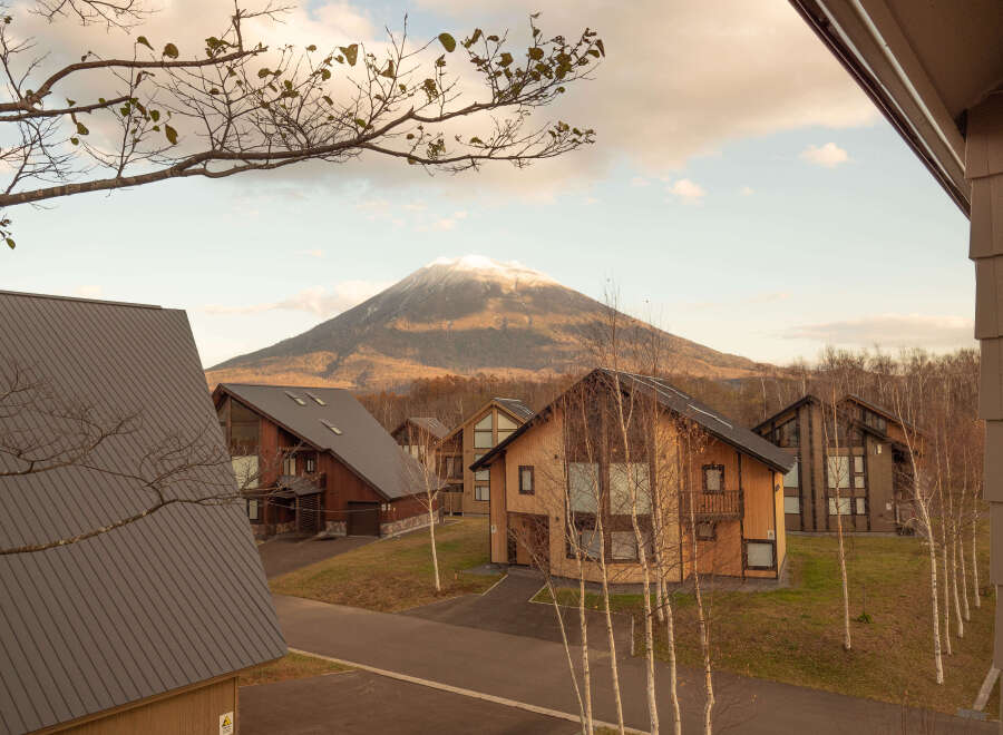 Luxury cabins nestled in a serene mountain setting, offering breathtaking views of snow-capped peaks.