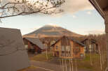 Luxury cabins nestled in a serene mountain setting, offering breathtaking views of snow-capped peaks.