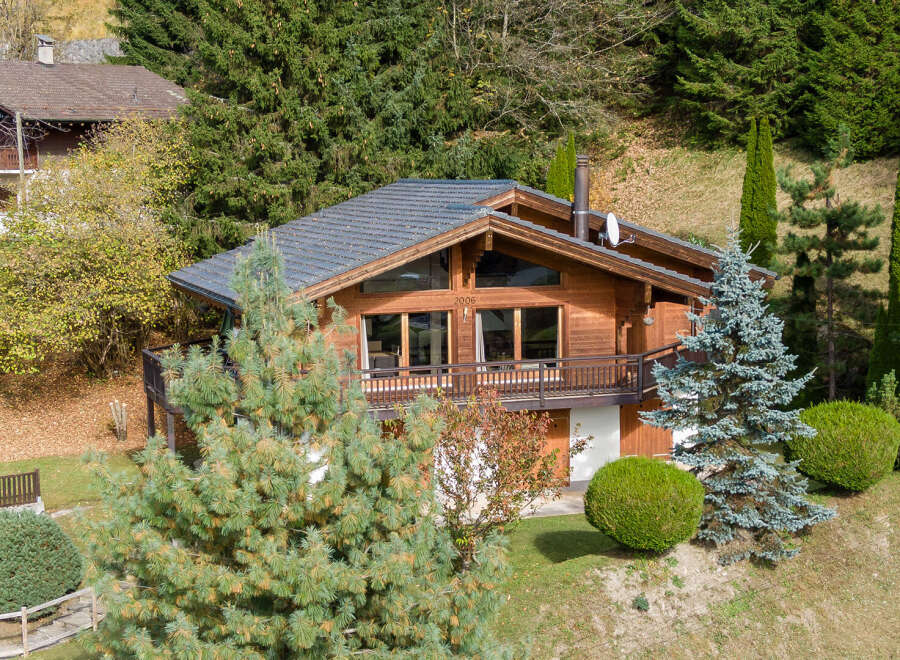 Discover a stunning wooden chalet nestled in a picturesque mountain setting.