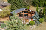 Discover a stunning wooden chalet nestled in a picturesque mountain setting.