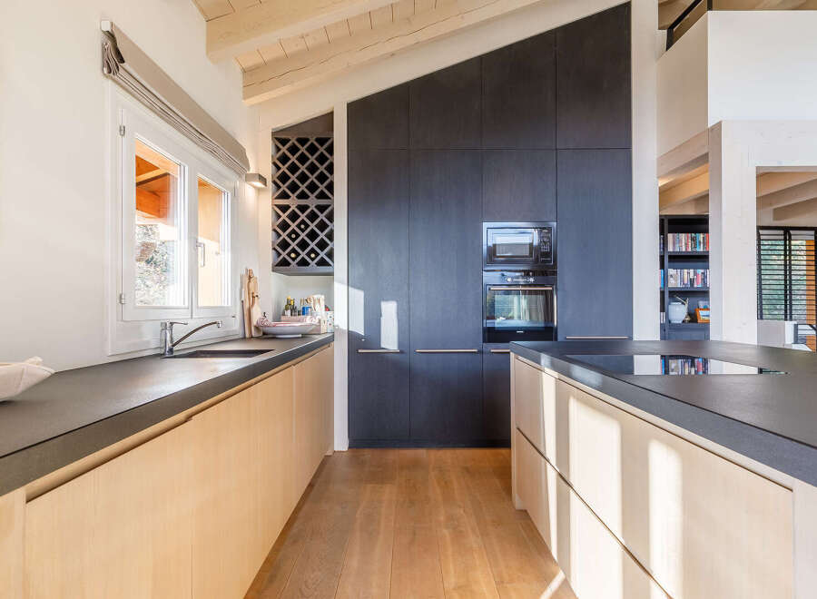 This stunning kitchen boasts a modern design with sleek countertops and light wood cabinetry.