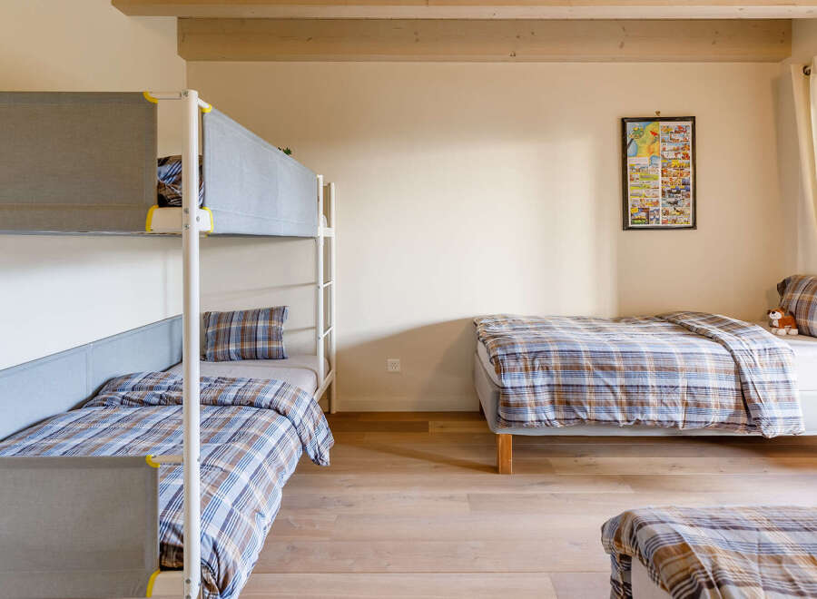 This cozy bedroom features a bunk bed and a single bed, perfect for a family or group of friends.