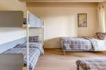 This cozy bedroom features a bunk bed and a single bed, perfect for a family or group of friends.