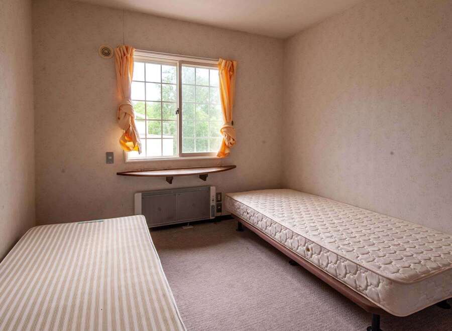 Cozy twin-sized bedroom with two single beds, perfect for roommates or guests.