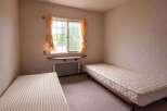 Cozy twin-sized bedroom with two single beds, perfect for roommates or guests.