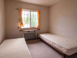 Cozy twin-sized bedroom with two single beds, perfect for roommates or guests.