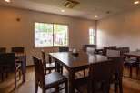 A cozy restaurant interior with multiple dark brown wooden tables and chairs, offering a comfortable dining experience.