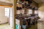This commercial kitchen boasts stainless steel countertops, a large sink, and ample storage.