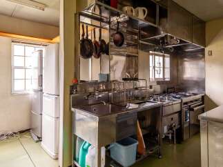 This commercial kitchen boasts stainless steel countertops, a large sink, and ample storage.