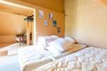Cozy attic bedroom with twin mattresses, ample pillows, and built-in closet.