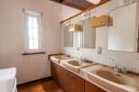 This property features a retro-style bathroom with three sinks, each with its own mirror and vintage faucets.