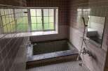 This charming bathroom boasts a vintage aesthetic with its dark gray tiled walls and flooring.