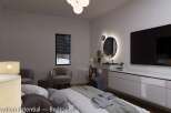 This bedroom boasts a stylish and modern design, featuring a large TV, comfortable seating, and a sleek vanity area with illuminated mirrors.