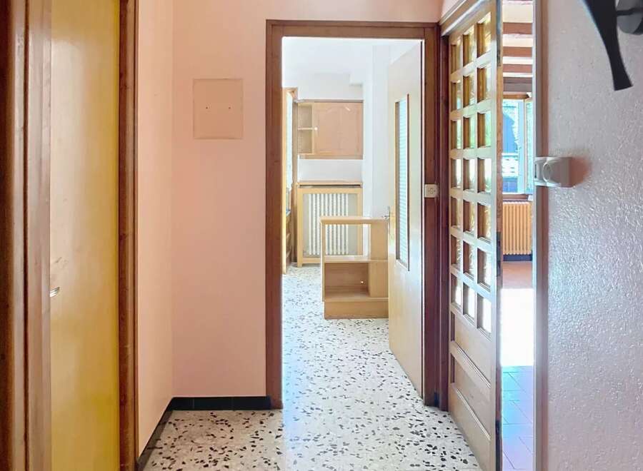 Step into this inviting hallway, showcasing a classic terrazzo floor and warm, neutral walls.