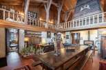 This stunning chalet boasts a magnificent open-plan living area with exposed wooden beams and a grand dining table, perfect for entertaining.