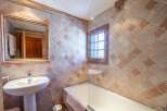 Charming bathroom with rustic tile and wood accents.