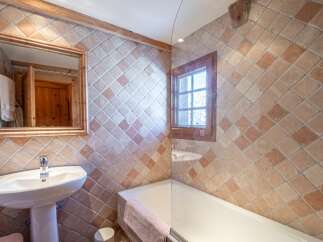 Charming bathroom with rustic tile and wood accents.
