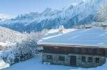 This stunning chalet boasts a picturesque snow-covered roof and breathtaking mountain views.