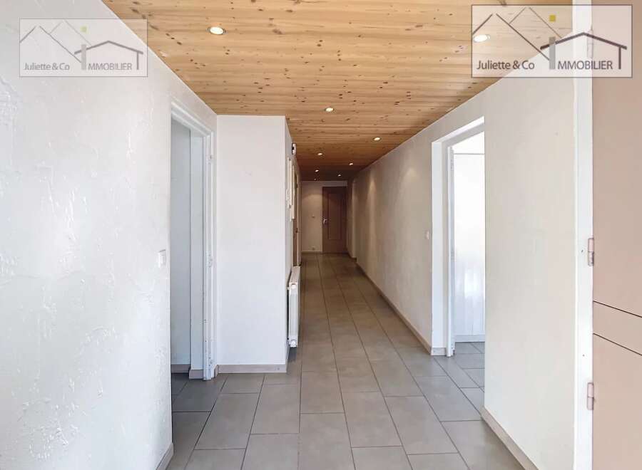 Discover this inviting property featuring a bright and airy hallway with a warm wooden ceiling.