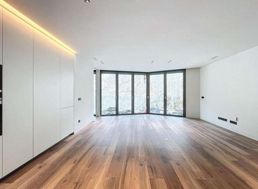 Stunning modern apartment boasting expansive windows offering abundant natural light and views.