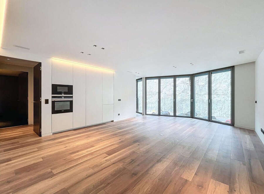 Stunning open-plan living space with expansive curved windows offering abundant natural light and views.