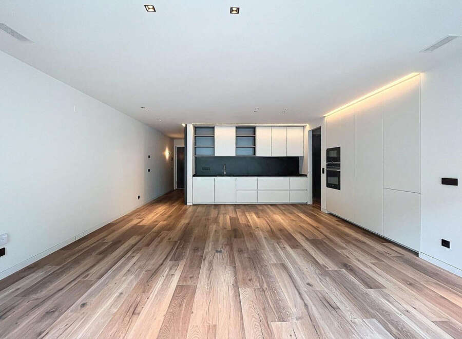 Stunning open-plan living space with sleek, modern kitchen and high-quality wood flooring.