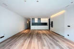 Stunning open-plan living space with sleek, modern kitchen and high-quality wood flooring.