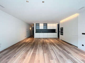 Stunning open-plan living space with sleek, modern kitchen and high-quality wood flooring.