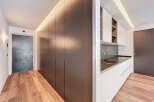 Modern apartment boasts sleek, built-in cabinetry and hardwood floors.