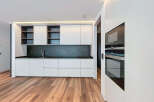 Modern kitchen with sleek white cabinets and dark countertops.