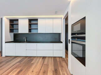Modern kitchen with sleek white cabinets and dark countertops.