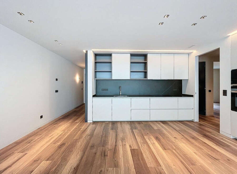 Stunning modern kitchen with sleek white cabinetry and dark countertops.