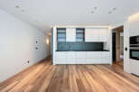 Stunning modern kitchen with sleek white cabinetry and dark countertops.