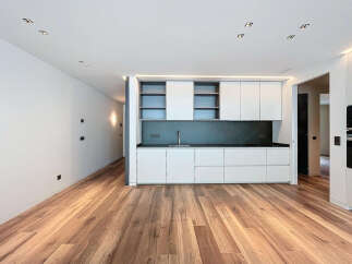 Stunning modern kitchen with sleek white cabinetry and dark countertops.